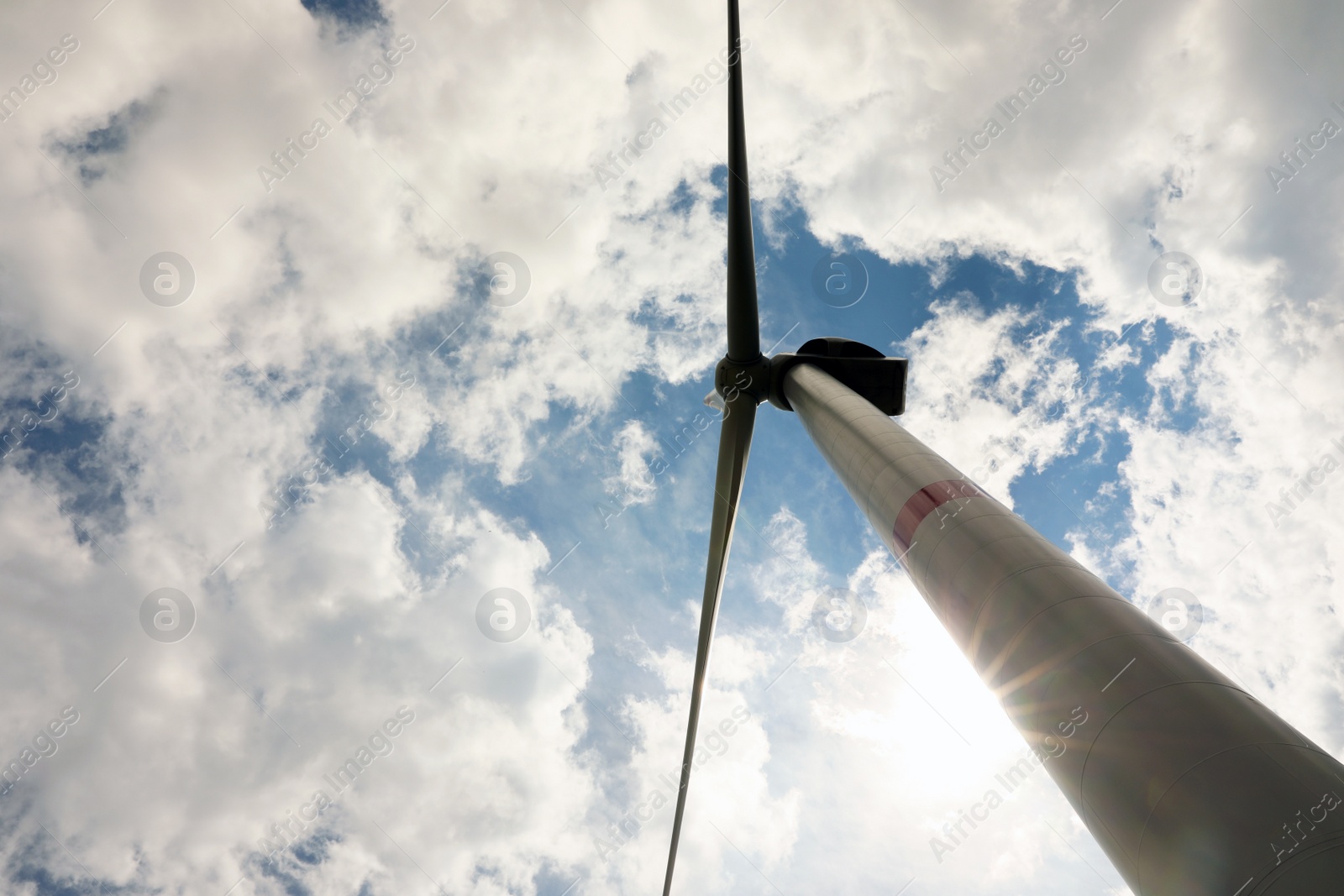 Photo of Modern wind turbine against cloudy sky, low angle view. Alternative energy source