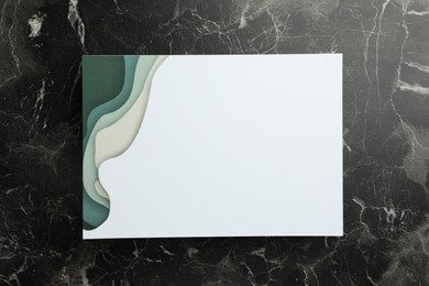 Photo of Blank invitation card on black marble background, top view. Space for text