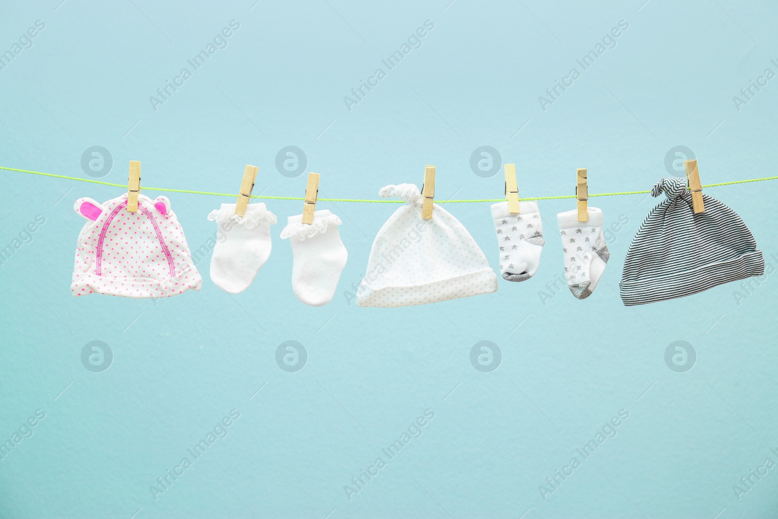 Photo of Children's clothes on laundry line against color background