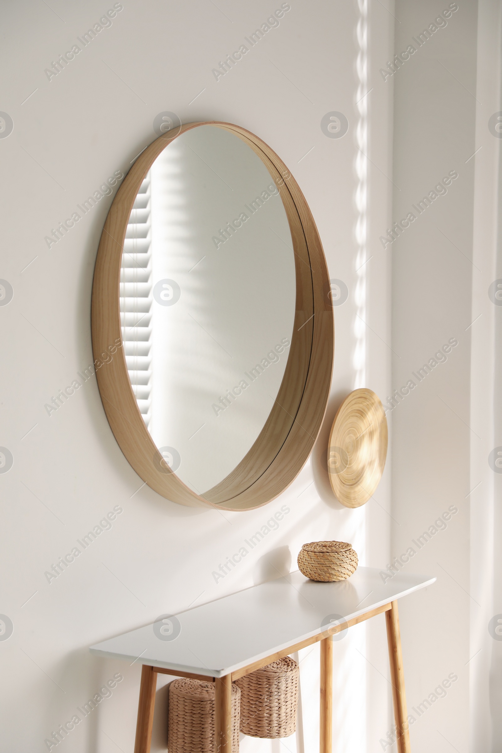 Photo of Stylish round mirror hanging on white wall in room