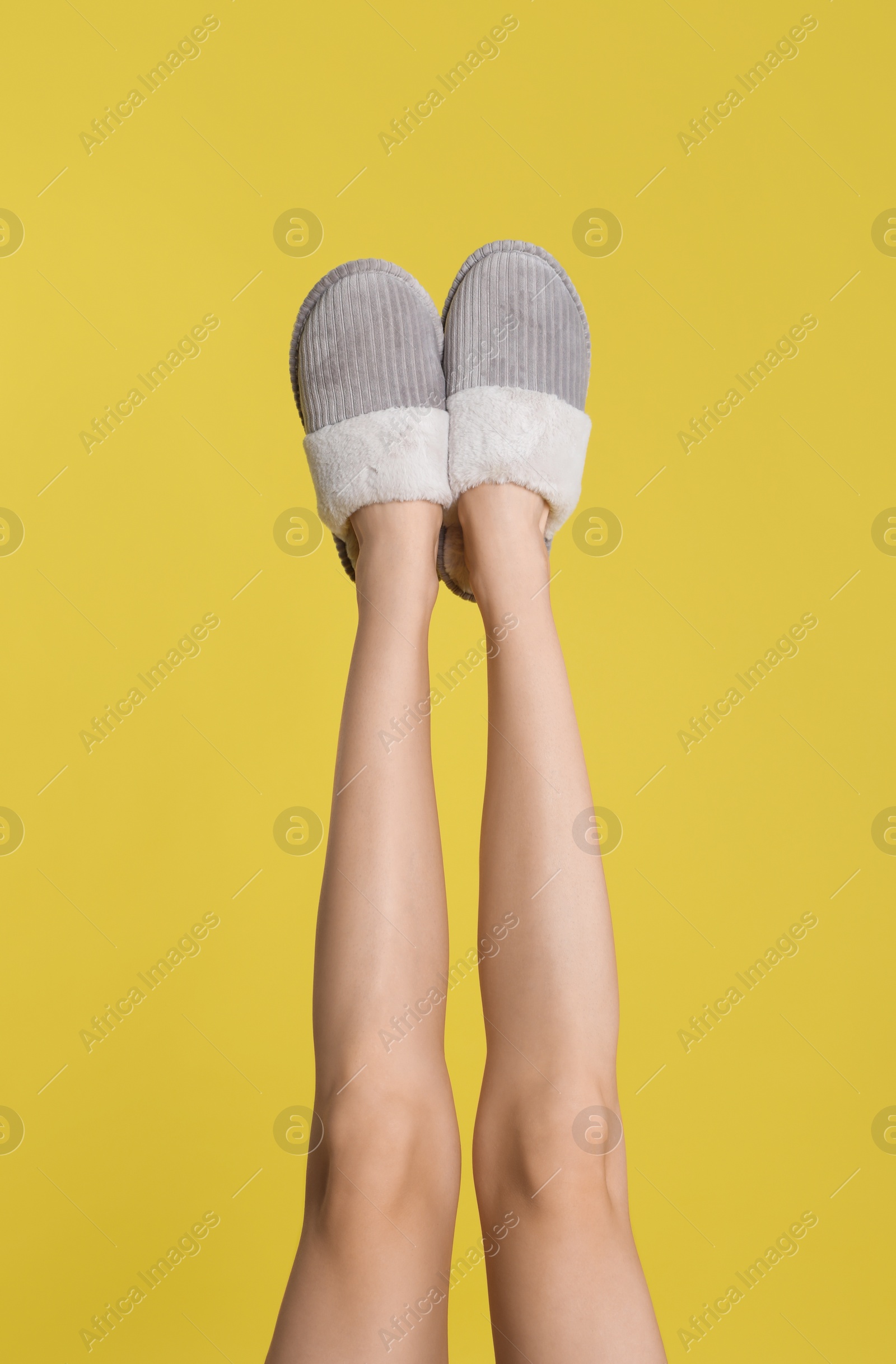 Photo of Woman wearing stylish slippers on yellow background, closeup