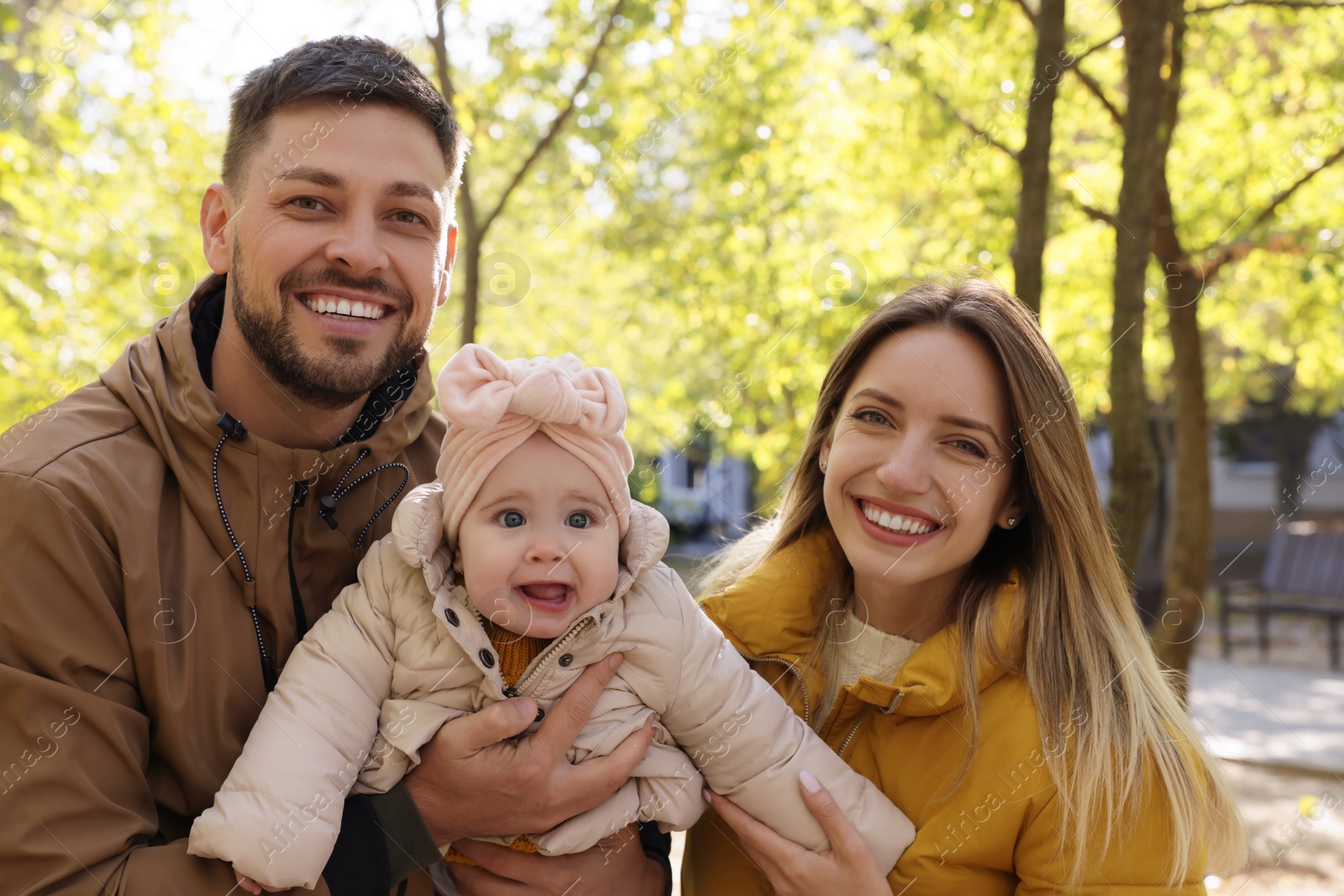 Photo of Happy parents with their baby in park on sunny day