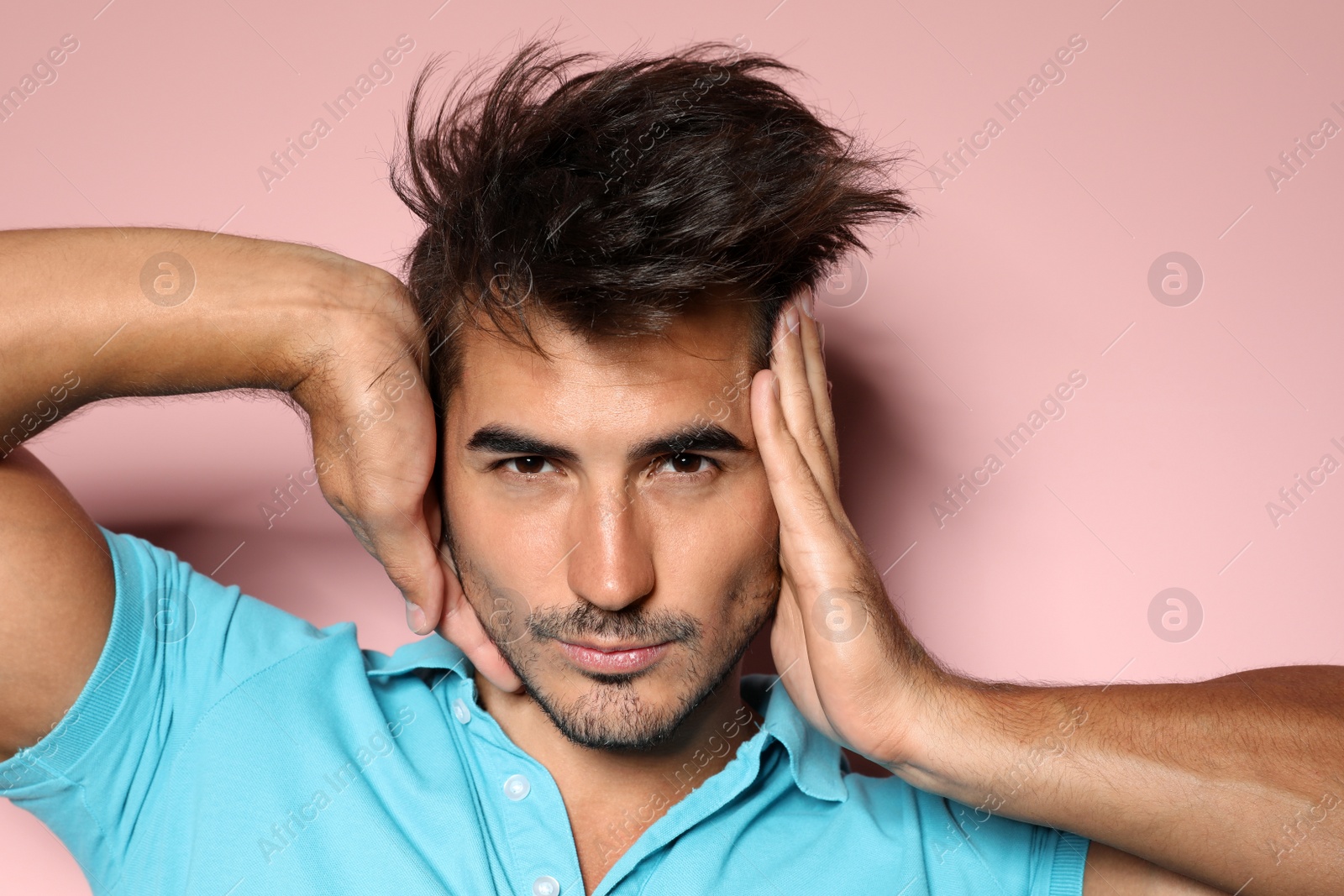 Photo of Young man with trendy hairstyle posing on color background