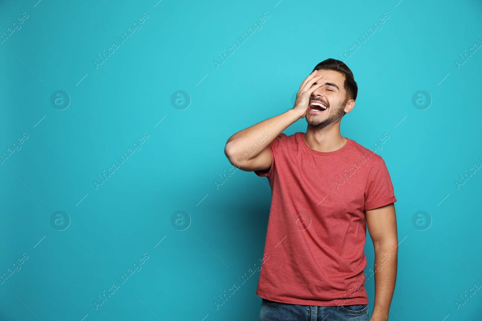 Photo of Handsome young man laughing against color background. Space for text