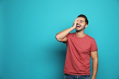 Photo of Handsome young man laughing against color background. Space for text