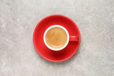 Photo of Aromatic coffee in red cup on light grey background, top view