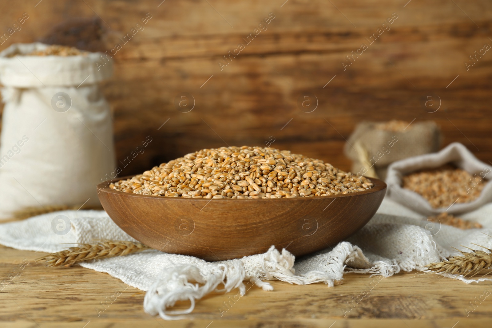 Photo of Bowl of wheat grains on wooden table