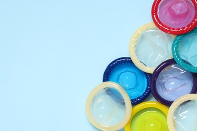 Photo of Condoms on light blue background, top view with space for text. Safe sex