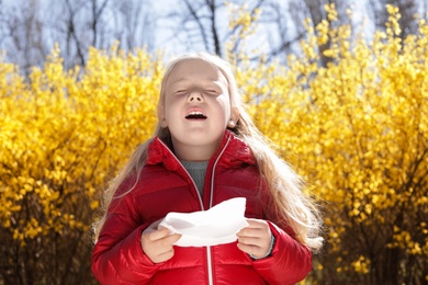 Photo of Little girl suffering from seasonal allergy outdoors