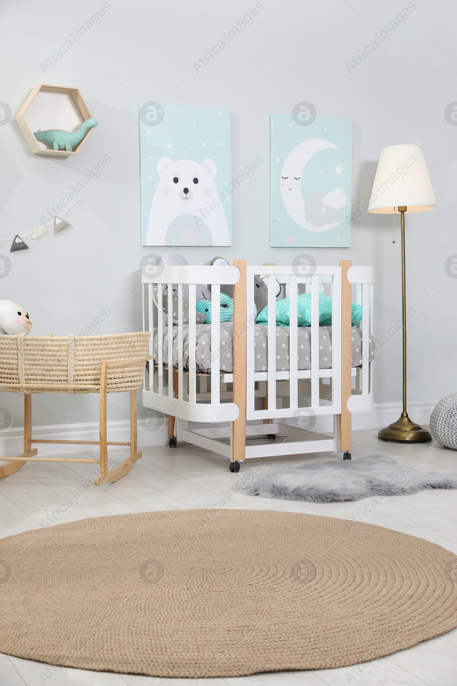 Photo of Cozy baby room with crib and other furniture. Interior design