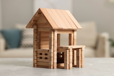 Wooden house on light grey table indoors, closeup. Children's toy