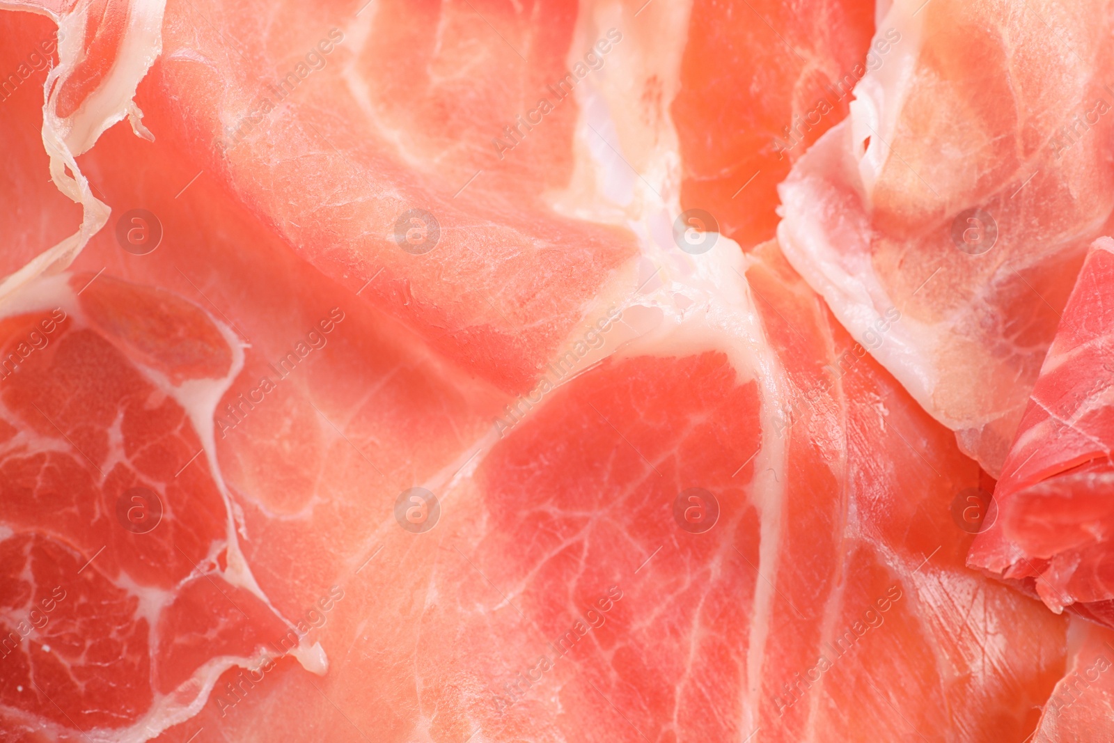 Photo of Tasty prosciutto slices as background, closeup view