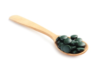 Spoon with spirulina tablets on white background