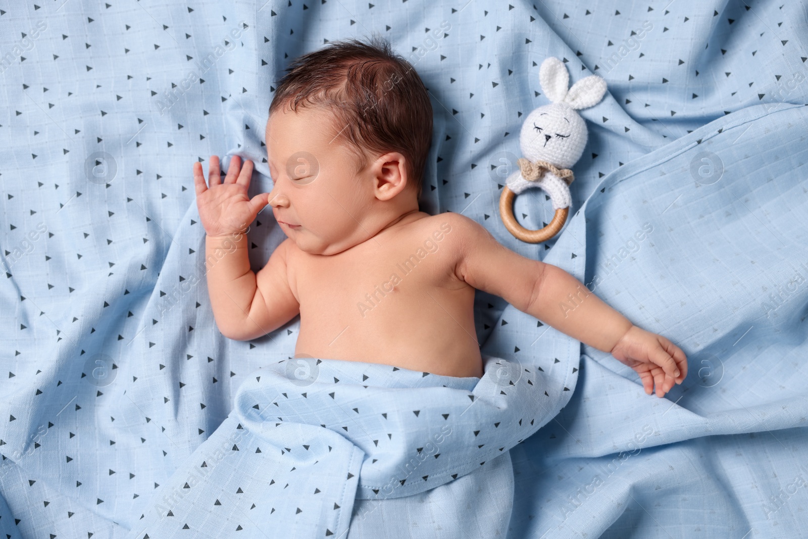 Photo of Cute newborn baby with toy bunny sleeping on bed, top view