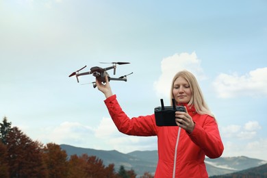 Photo of Young woman with modern drone in mountains