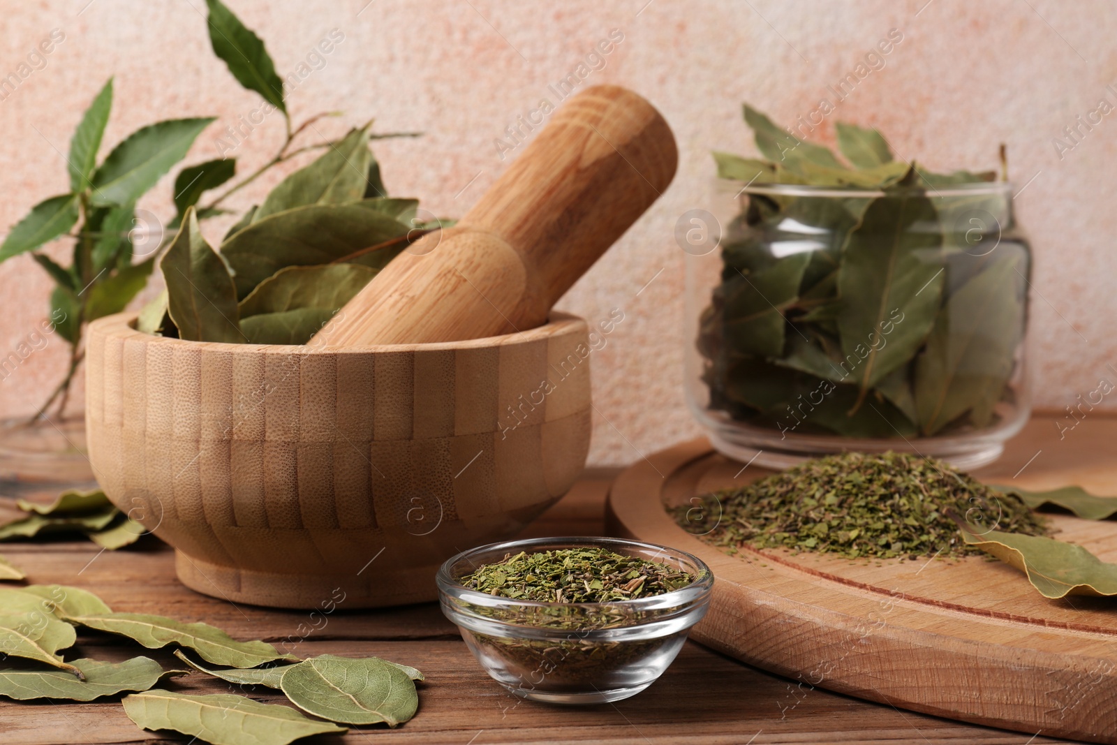 Photo of Whole and ground aromatic bay leaves on wooden table