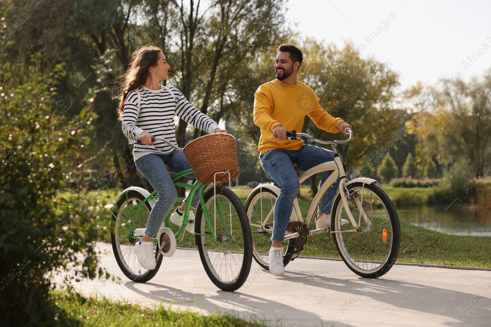 Photo of Beautiful young couple riding bicycles in park