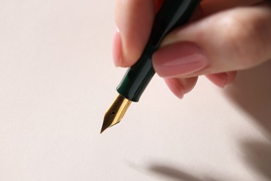 Woman writing with fountain pen, closeup view