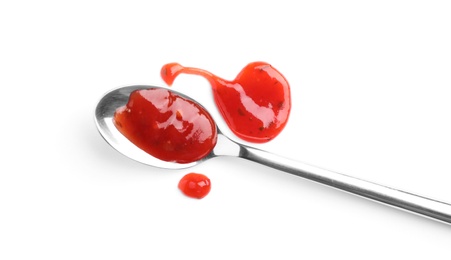 Metal spoon and red sauce on white background, top view