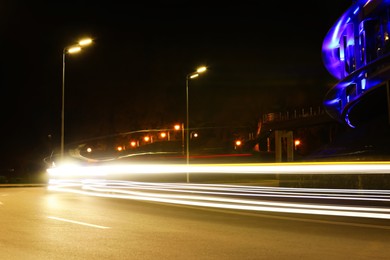 Photo of Road with light trails in modern city. Night life