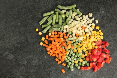 Mix of different frozen vegetables on gray table, top view. Space for text