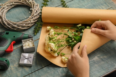 Female florist making beautiful bouquet at table