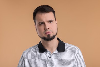 Photo of Portrait of sad man on beige background