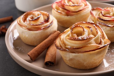 Photo of Freshly baked apple roses on grey table, closeup. Beautiful dessert