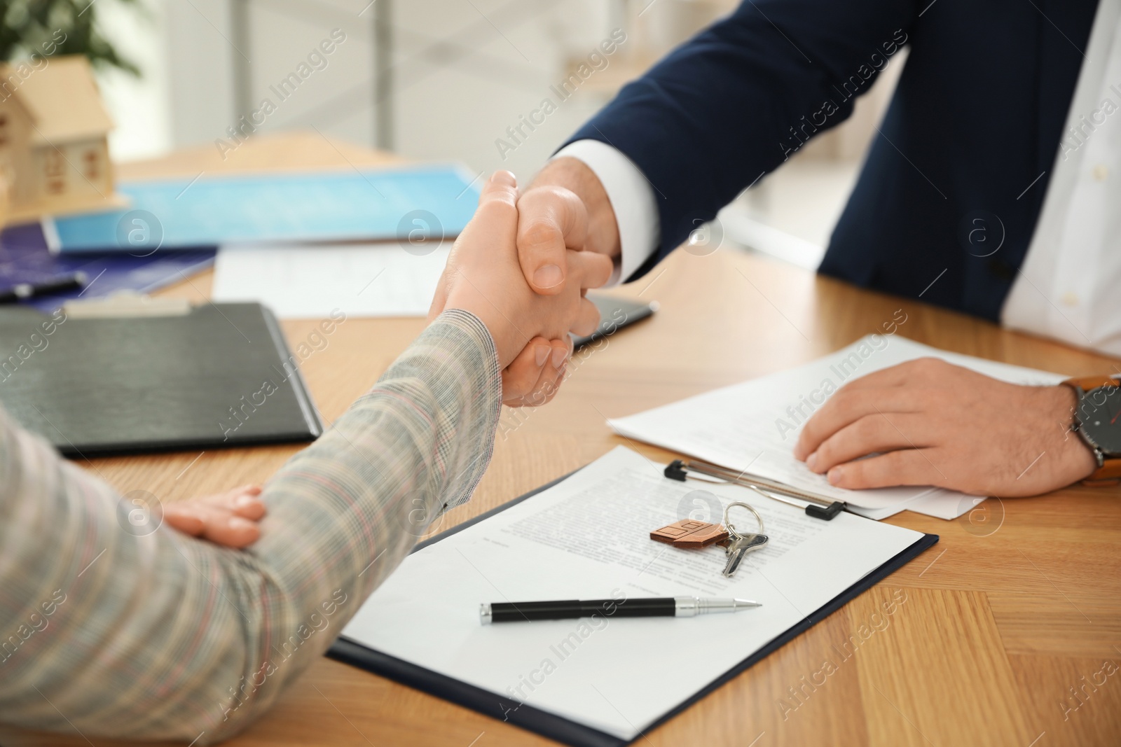 Photo of Real estate agent shaking hands with client in office, closeup