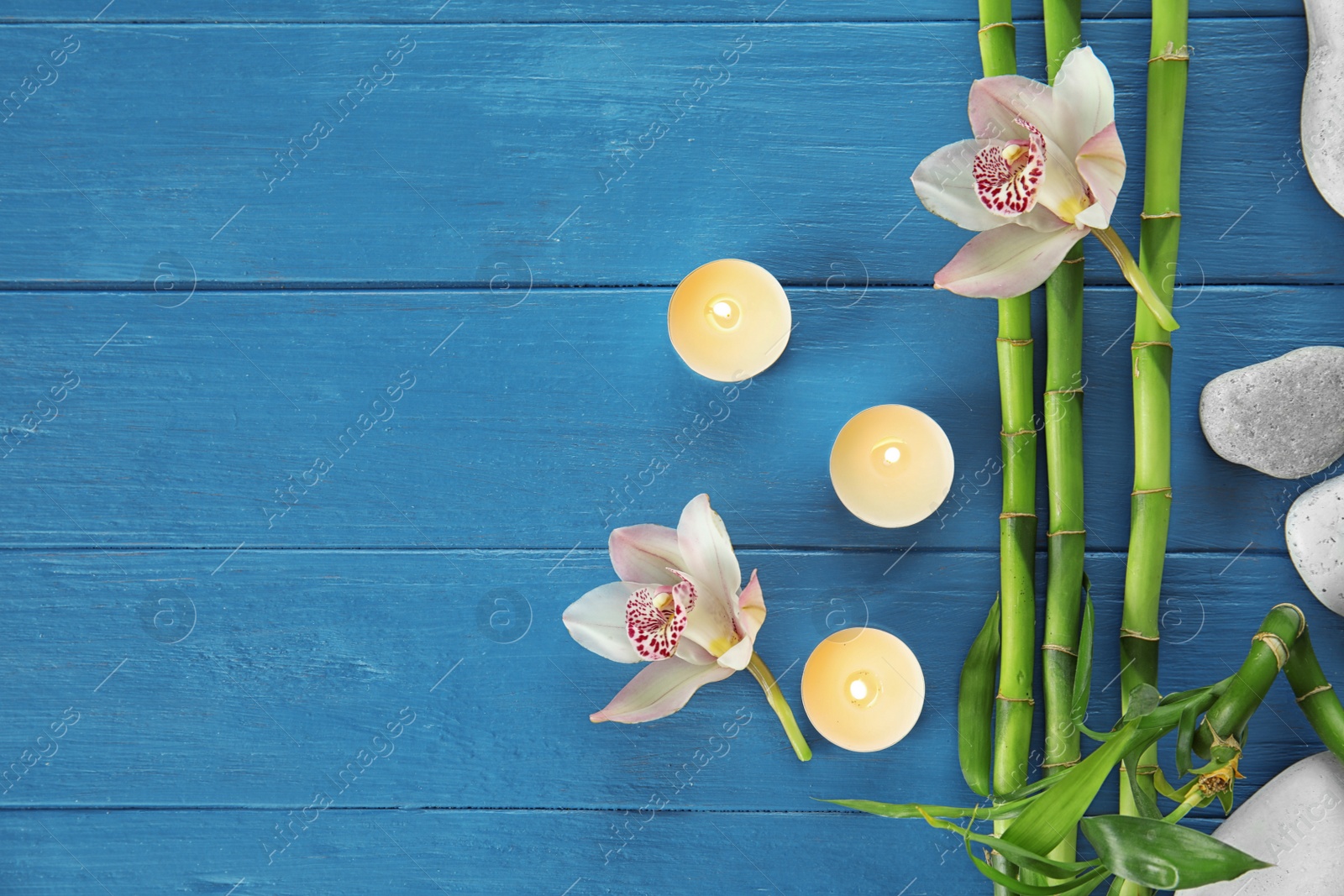 Photo of Flat lay composition with bamboo branches and orchids on wooden background. Space for text