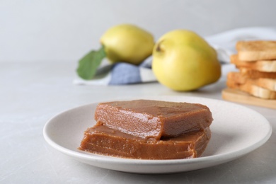 Photo of Delicious quince paste on white table, closeup