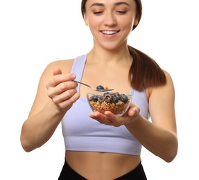 Happy woman eating tasty granola with fresh berries on white background, selective focus