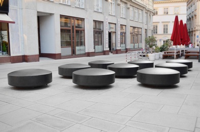 Photo of VIENNA, AUSTRIA - JUNE 18, 2018: Small circular benches on city street