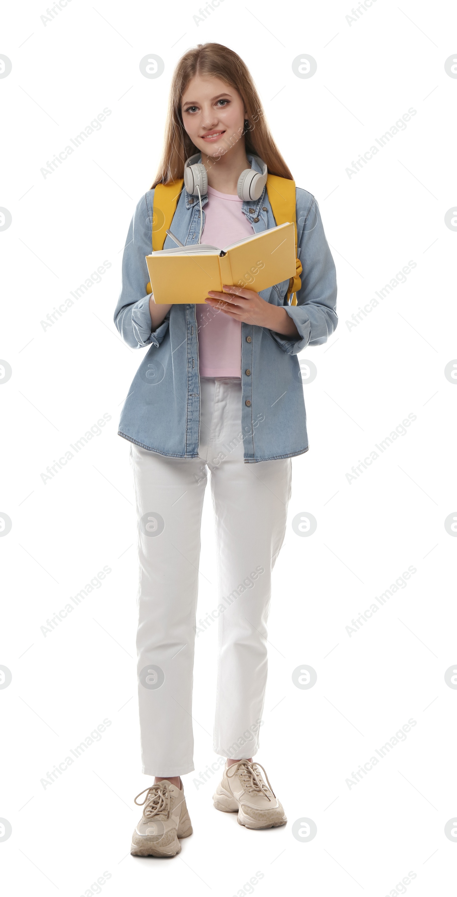 Photo of Teenage student with backpack, book and headphones on white background