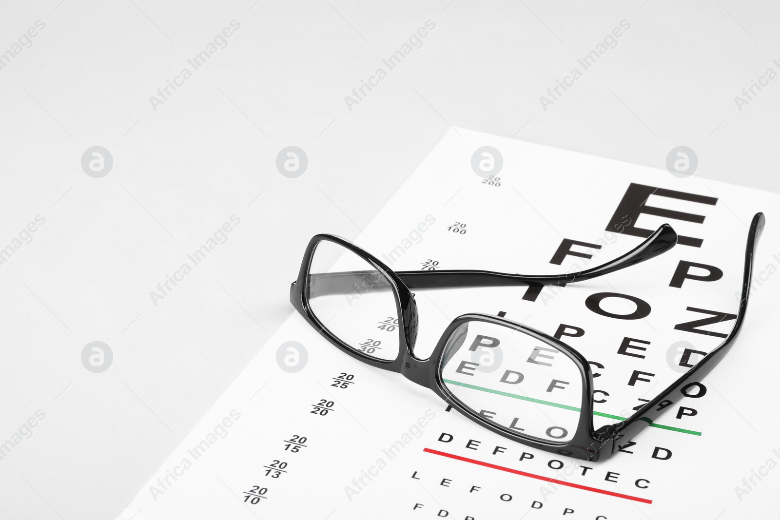 Photo of Glasses and vision test chart isolated on white