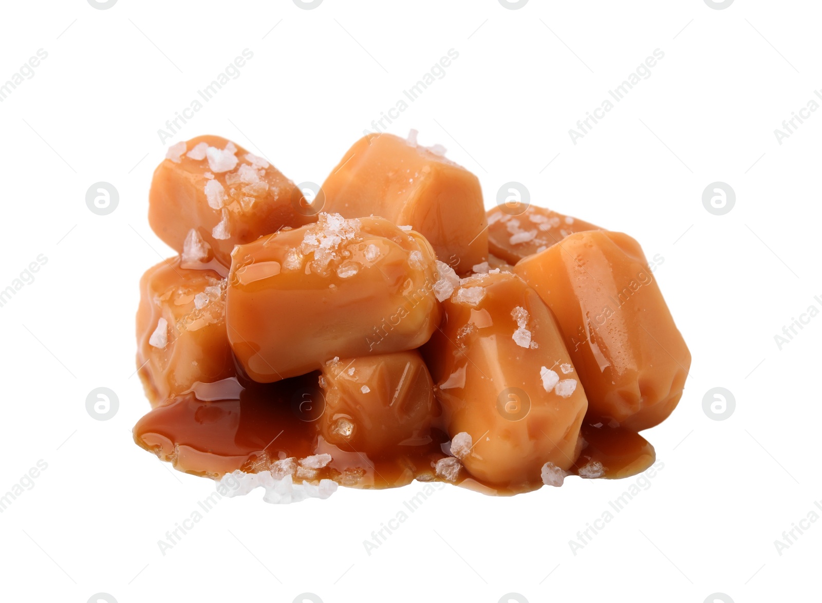 Photo of Yummy caramel candies and sea salt isolated on white