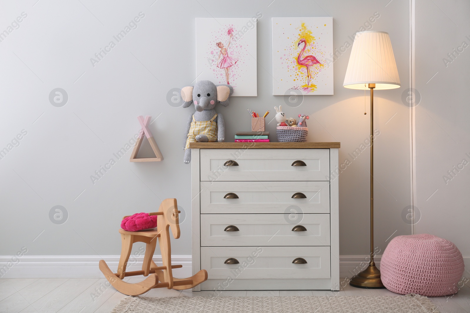 Photo of Chest of drawers and beautiful pictures in children's room. Interior design