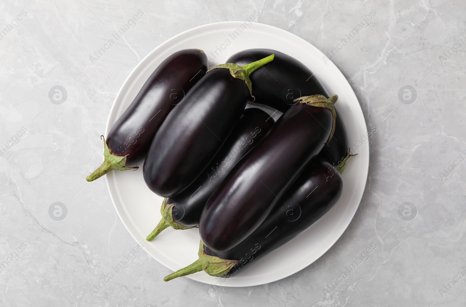 Photo of Raw ripe eggplants on grey table, top view