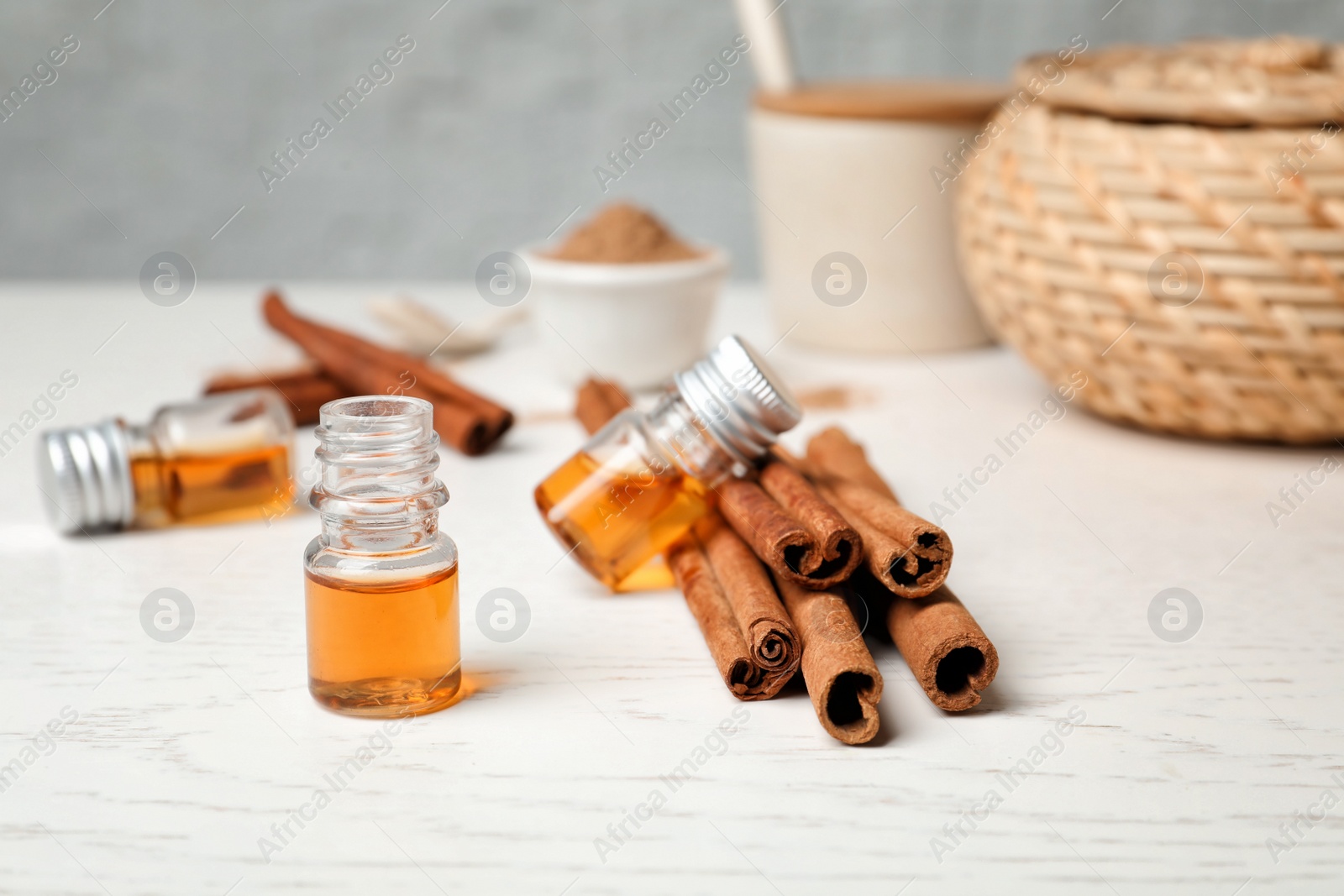 Photo of Closeup of bottle with cinnamon oil and sticks on wooden table