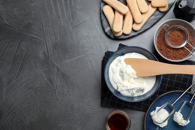 Photo of Flat lay composition with different tiramisu ingredients on black table, space for text