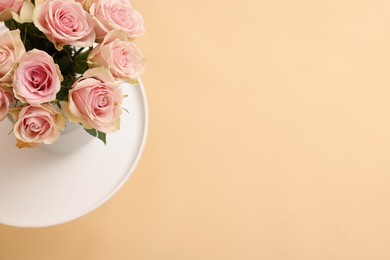 Photo of Beautiful bouquet of rose flowers on coffee table, above view and space for text