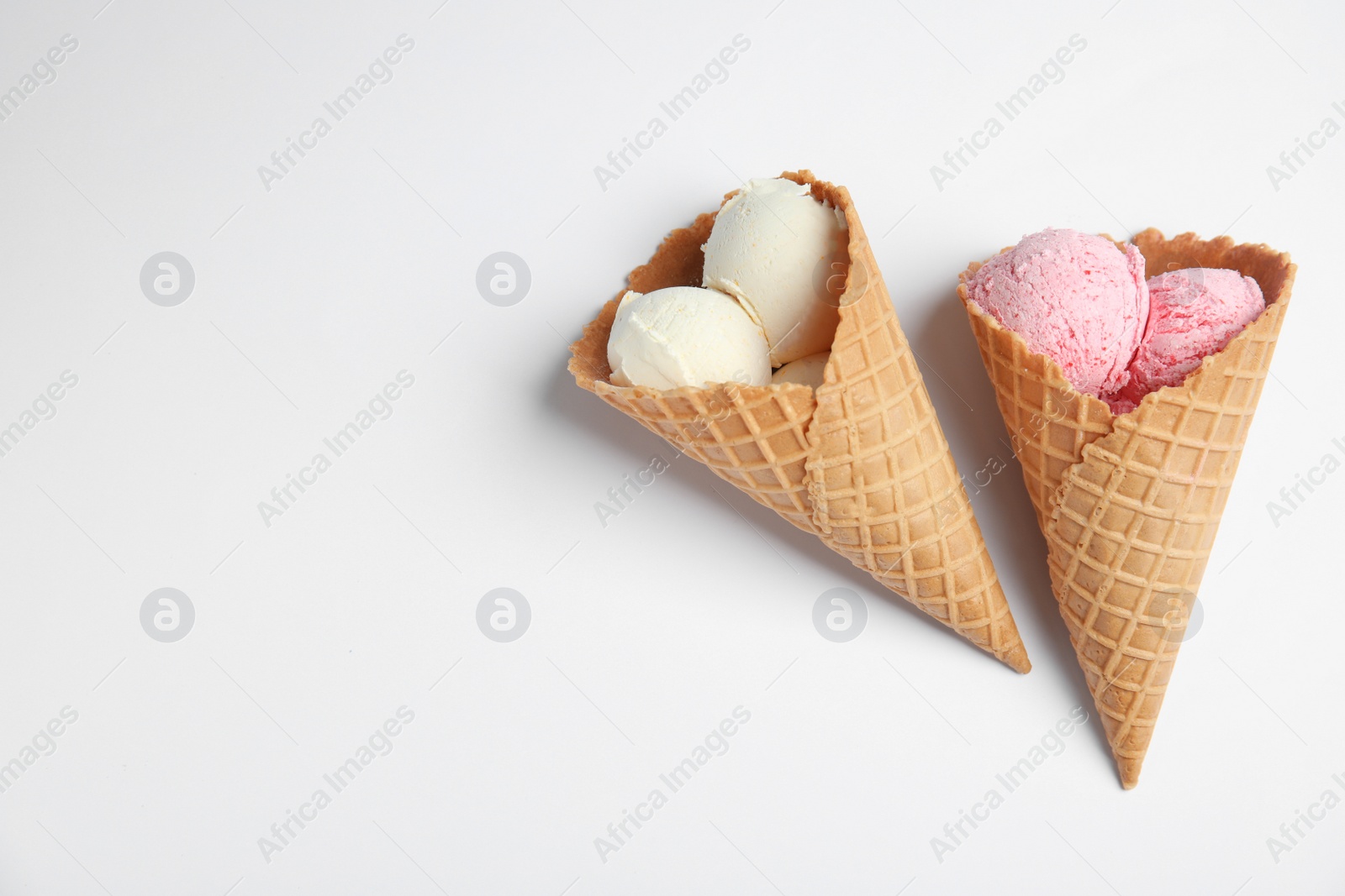 Photo of Delicious ice creams in wafer cones on white background, top view