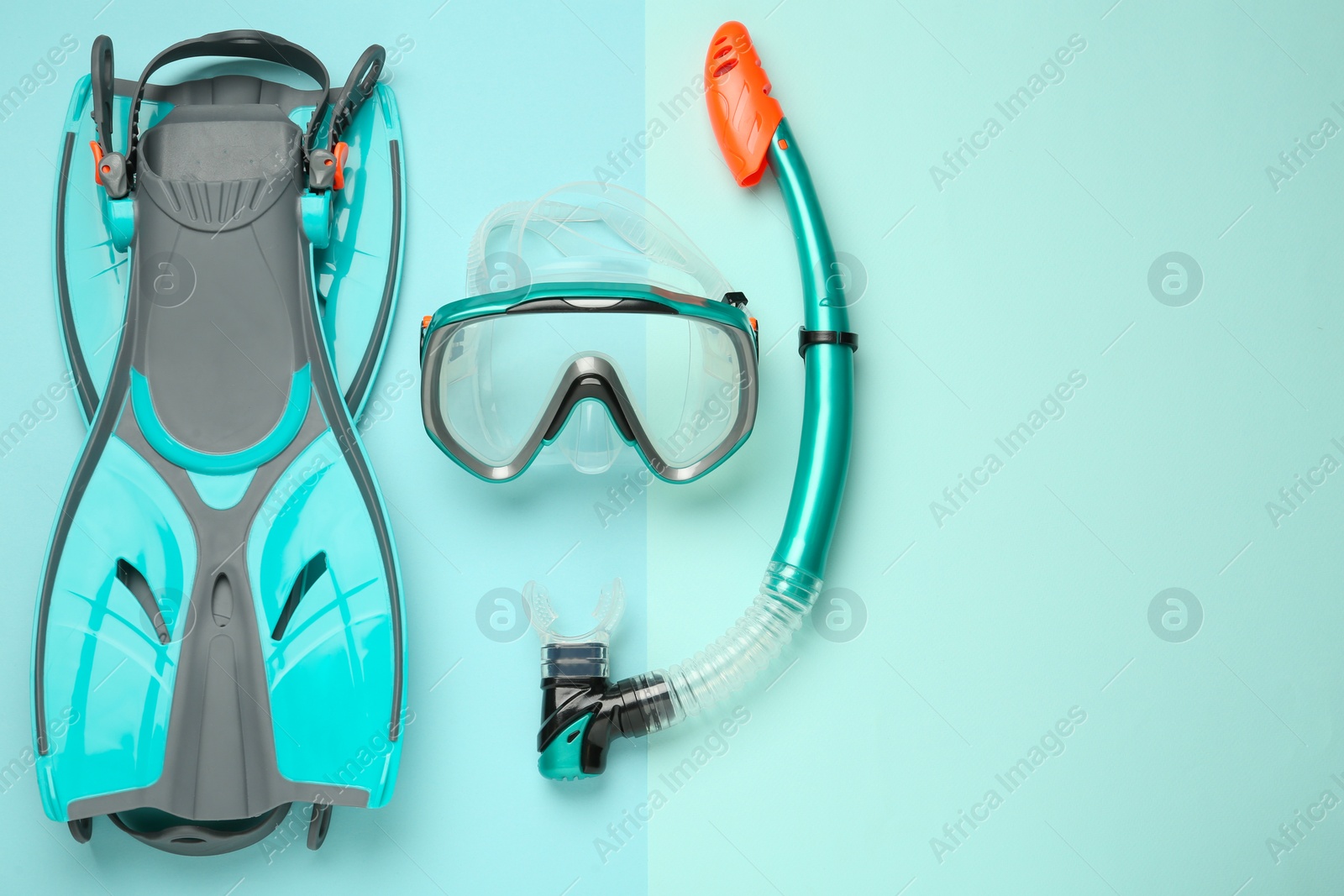 Photo of Pair of flippers, snorkel and diving mask on turquoise background, flat lay