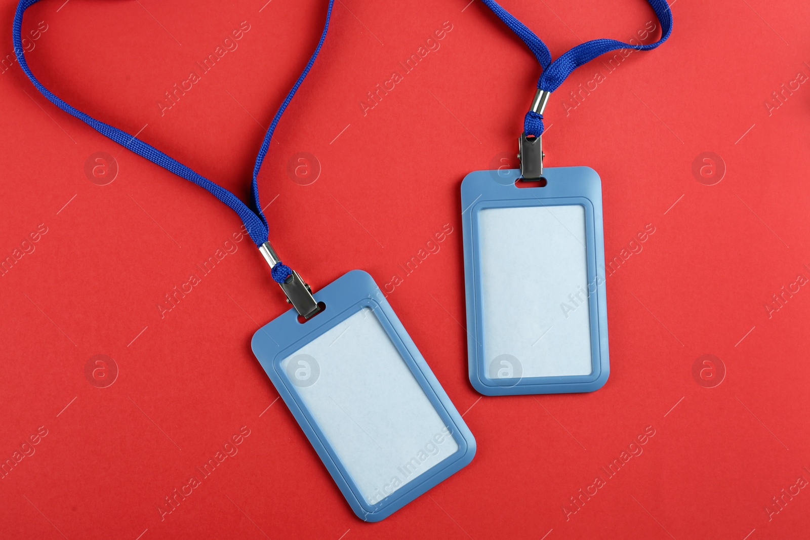 Photo of Blank badges on red background, flat lay. Mockup for design