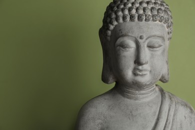 Beautiful stone Buddha sculpture on green background. Space for text