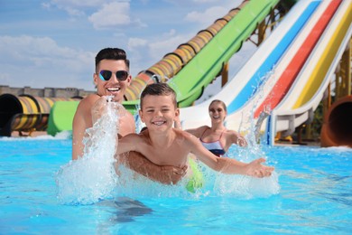 Photo of Happy family playing in swimming pool at water park