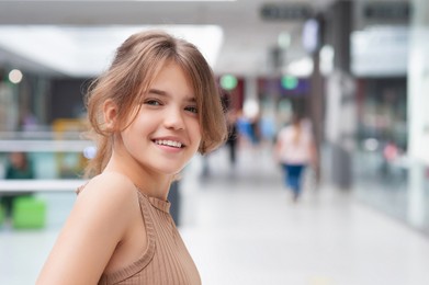 Portrait of beautiful teenage girl in shopping mall. Space for text