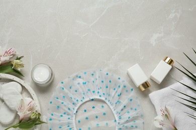 Photo of Flat lay composition with shower cap and toiletries on grey marble background. Space for text