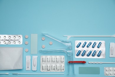 Photo of Sterile gynecological examination kit and pills on light blue background, flat lay. Space for text