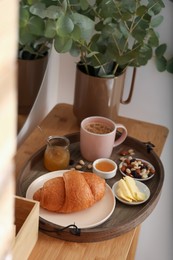 Tray with tasty breakfast on dressing table